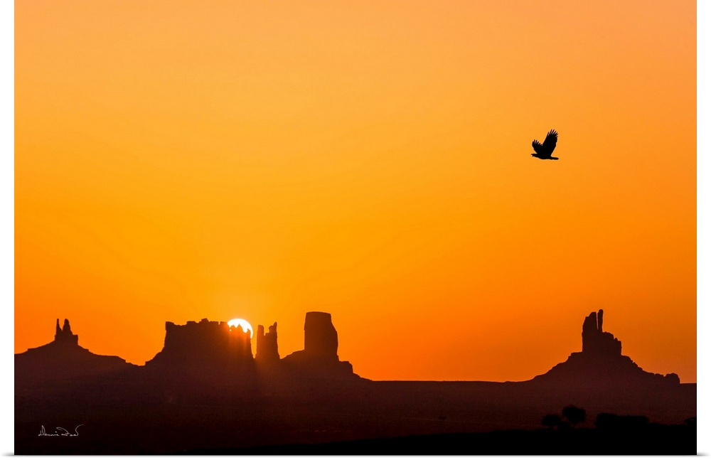 Composite of glorious sunrise over the mittens of Monument Valley with a silhouette of a Bald Eagle, Arizona, USA.
