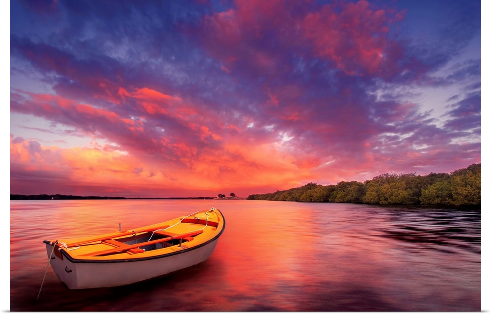 A rowboat watches an amazing sunset.