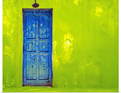 Blue Door In A Shabby Green Wall