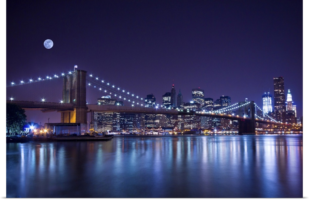 New York City's Brooklyn Bridge at night under a full moon.