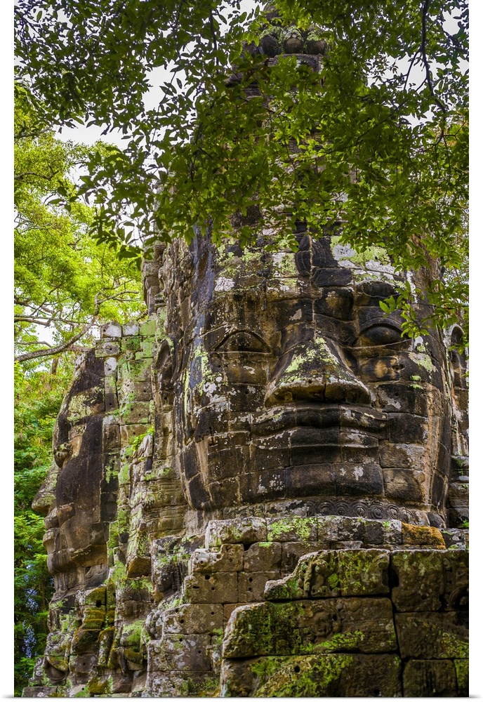Cambodia, Siem Reap, Angkor, Giant stone faces at one of the gates inside the Angkor Thom temple complex.