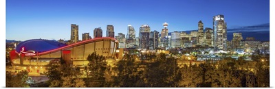 Canada, Alberta, Calgary, Skyline of downtown Calgary and Saddledome illuminated at dusk