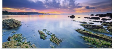 England, Cornwall, Rocks surfacing from the low tide seaside at dawn near Looe village