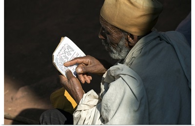 Ethiopia, Amhara, Lalibela, Monk reading Bible at Biete Abba Libanos