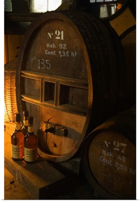 France, Normandy, Barrels and bottlesn of Calvados in a producer's cellar