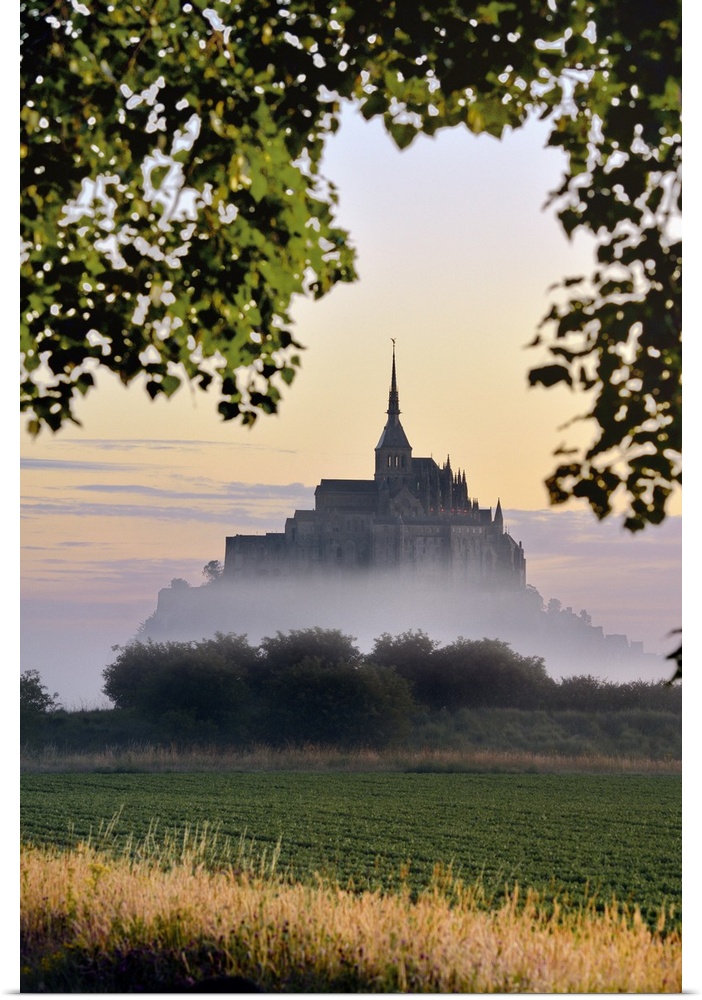 France, Normandy, Mont Saint-Michel, Atlantic ocean, Basse-Normandie, Le Mont-Saint-Michel at dawn appears in the fog.