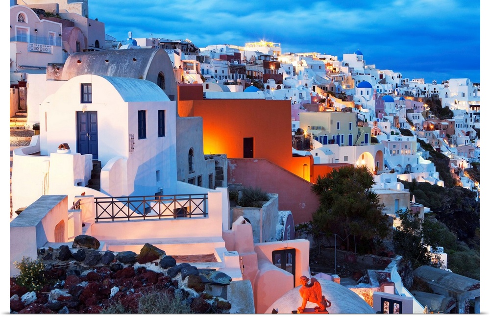 Greece, Aegean islands, Cyclades, Santorini island, Greek Islands, Oia village illuminated at dusk.