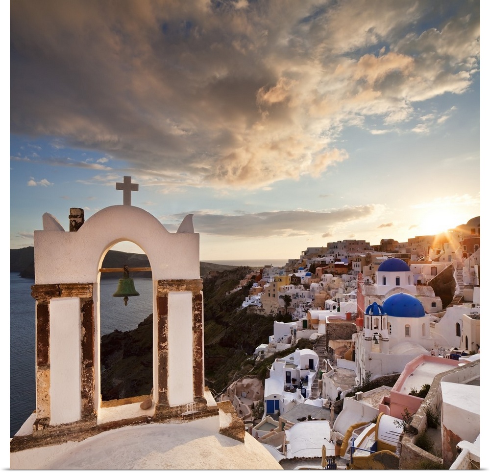 Greece, Aegean islands, Cyclades, Santorini island, Greek Islands, Oia, typical church bell overlooking the village at sun...