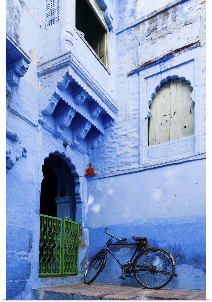 India, Rajasthan, Jodhpur, Bike resting against a wall of a blue house.
