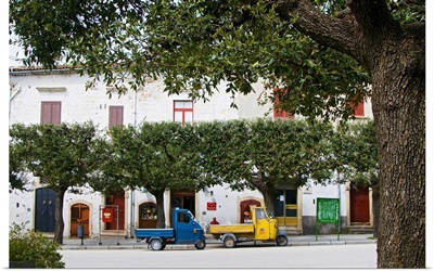 Italy, Apulia, Bovino, Two motorcars called Ape parked under the trees