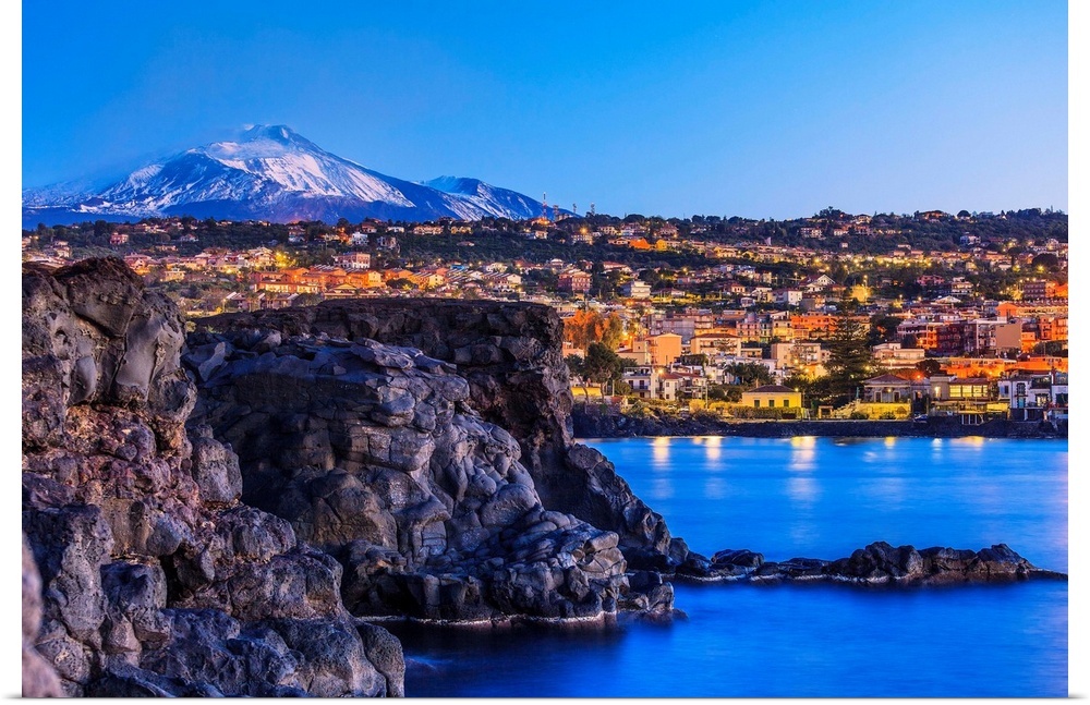 Italy, Sicily, Catania district, Ognina, Mediterranean sea, Lava stone rocks with Mt Etna in the background.