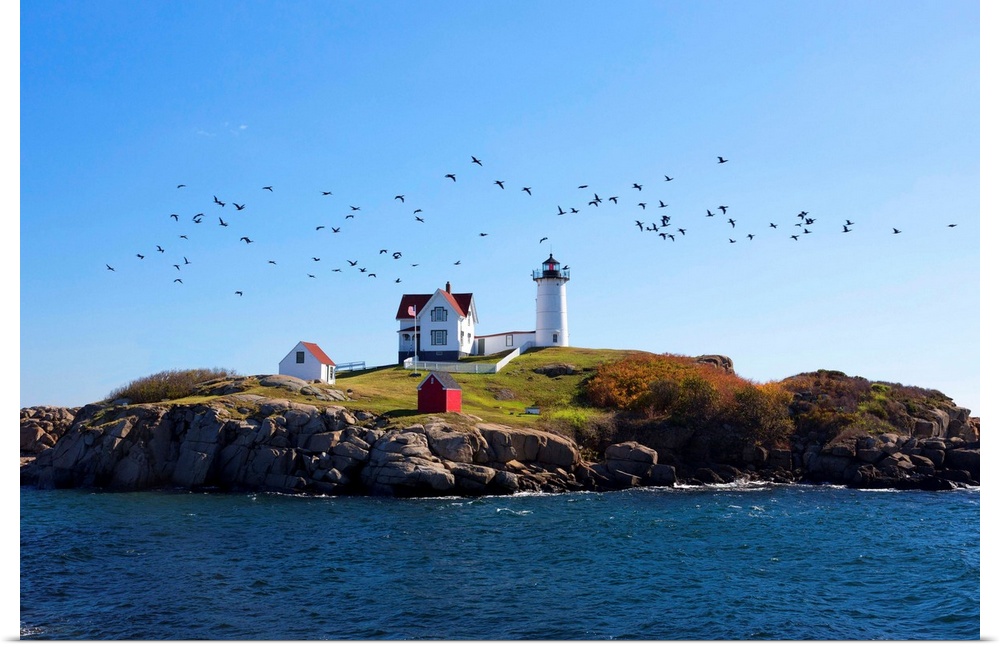 USA, Maine, Cape Neddick, New England, Atlantic, Nubble Lighthouse on the Savage Rock with a flock of birds flying by.