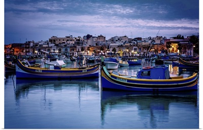 Malta, Marsaxlokk, Luzzu, traditional fishing boats and Marsaxlokk harbor at dusk