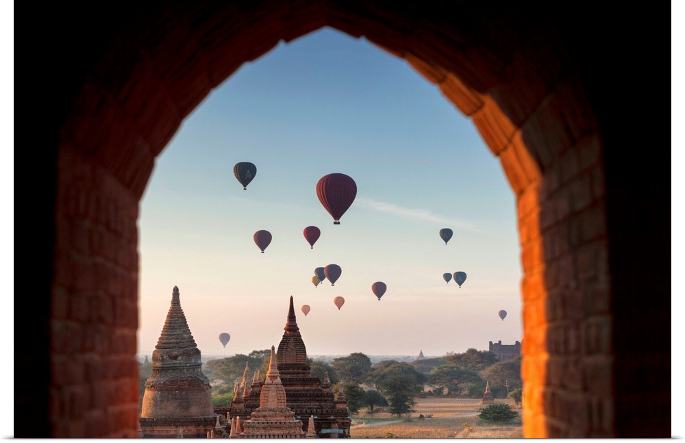 Myanmar, Mandalay, Bagan at dawn, Buddhist Temple, Stupas with desert land sky full of hot-air balloons.