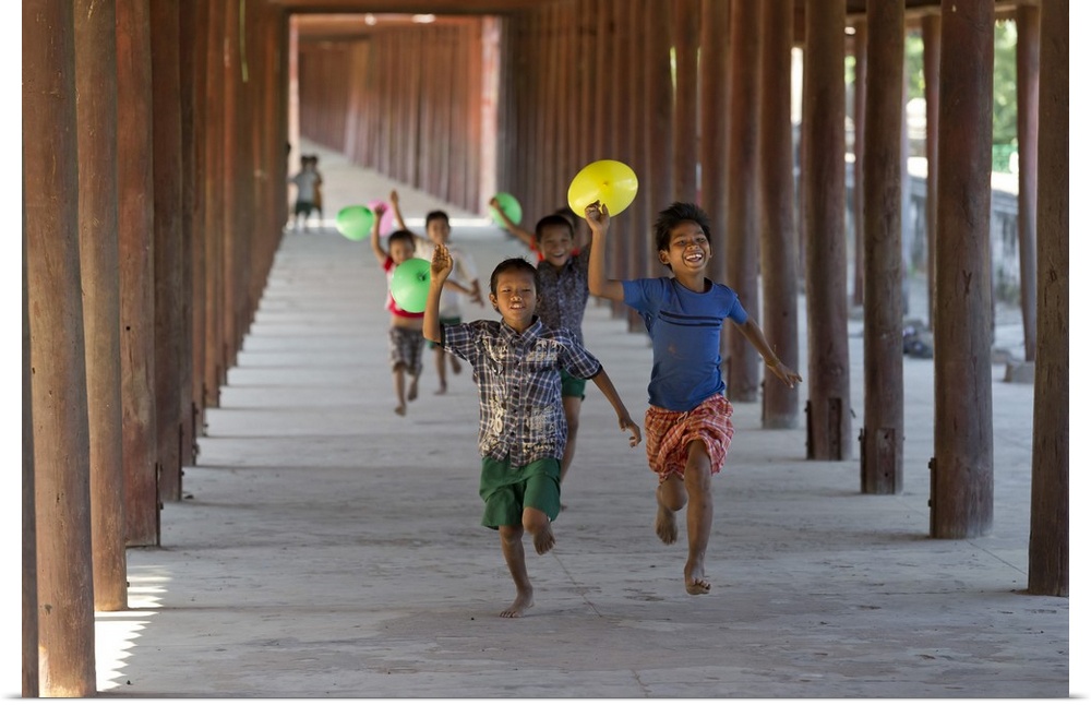 Myanmar, Mandalay, Bagan, Local children running along a passage with balloons.
