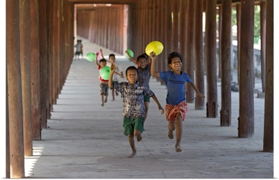 Myanmar, Mandalay, Bagan, Local children running along a passage with balloons