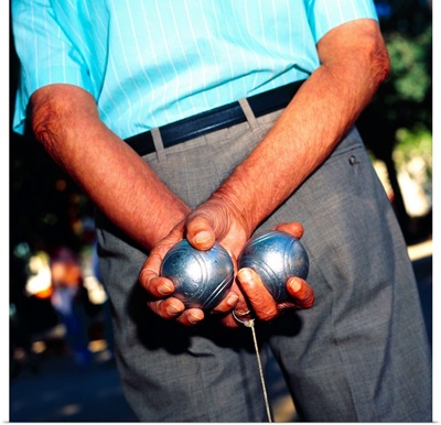Spain, Barcelona, Man holding two boules behind his back