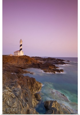 Spain, Minorca, Far de Favaritx lighthouse and rugged coastline at dawn