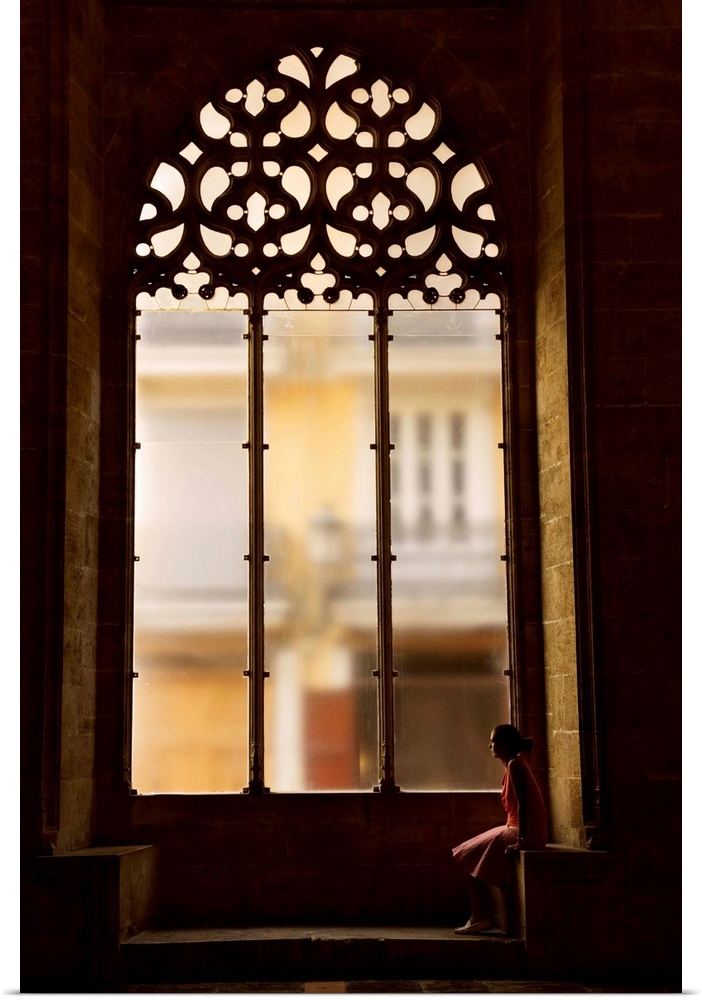 Spain, Comunidad Valenciana, Valencia, Hall of Lonja de La Seda, Woman sitting by a window