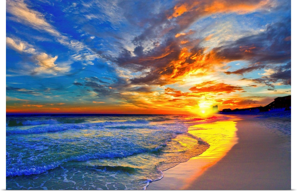 An amazing sunset with red and blue sky and clouds. A blue seascape and beach below.