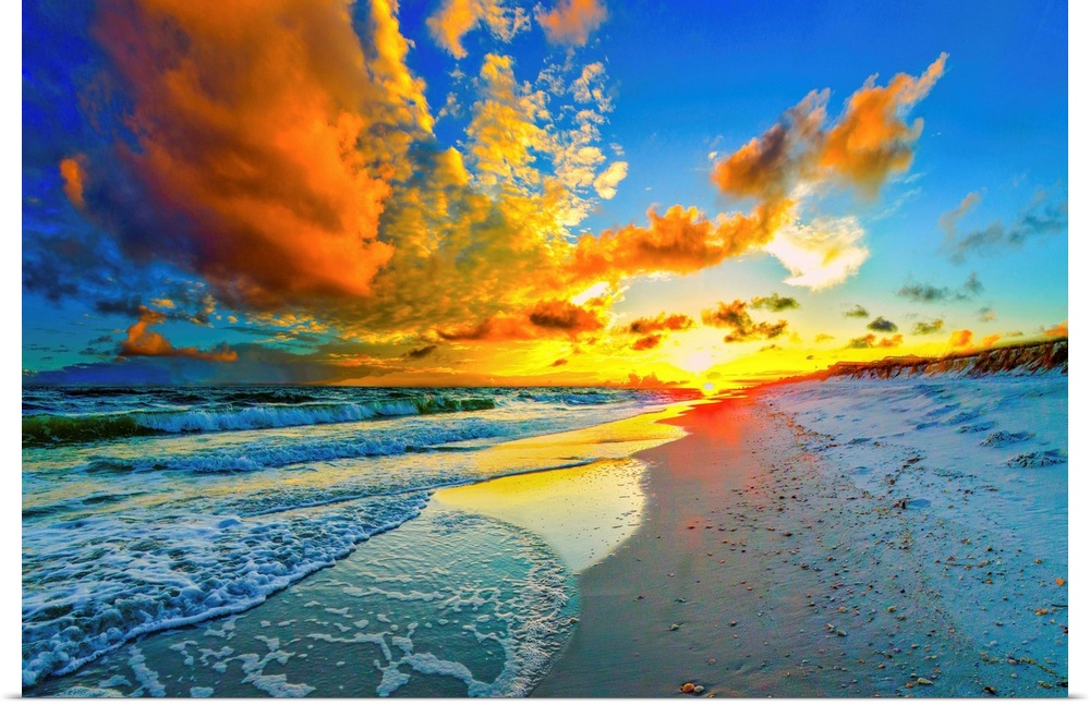 A dark and beautiful blue sky at sunset. An orange sunset expands outward from a yellow sun over a beach and seascape sunset.