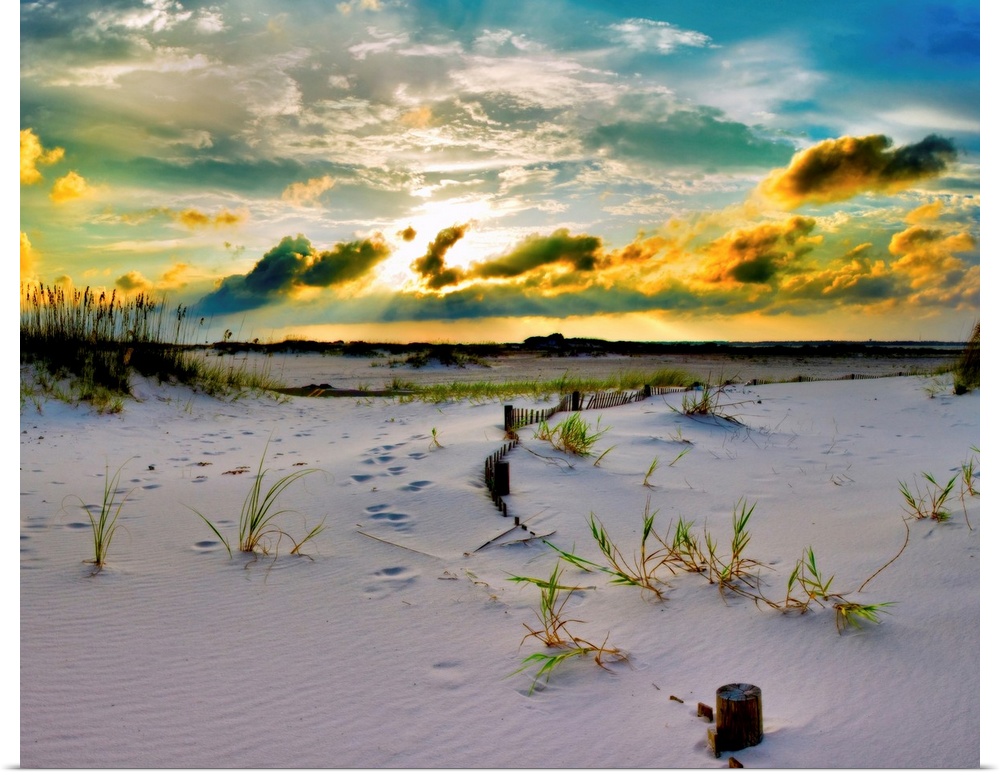 A golden sunset over a sandy pathway through the dunes down to the beach. Landscape taken near Pensacola Beach, Florida.