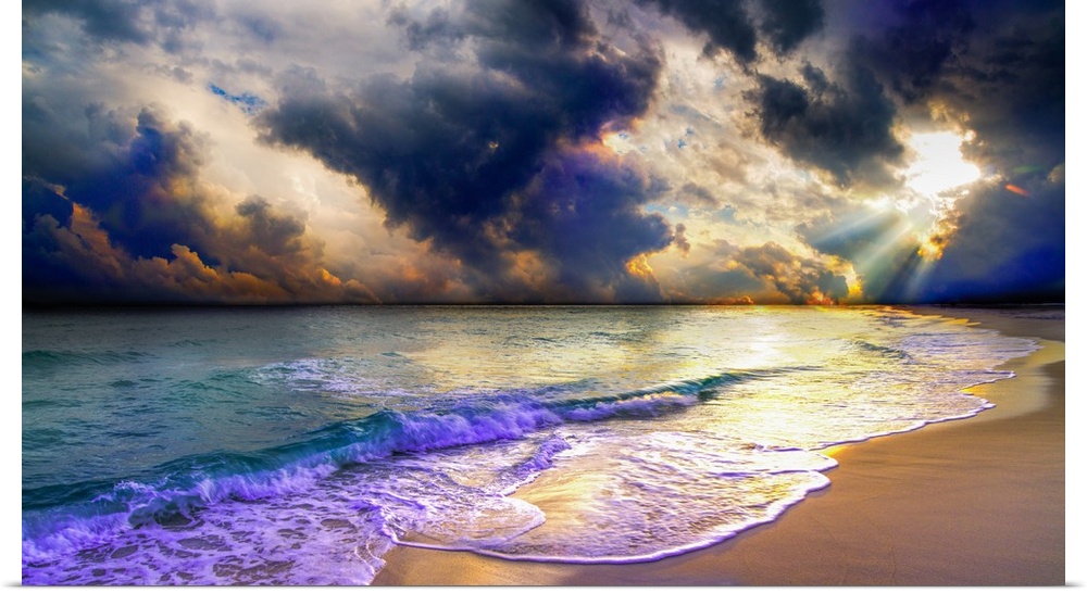 A panoramic beach sunset with blue clouds and ocean waves.