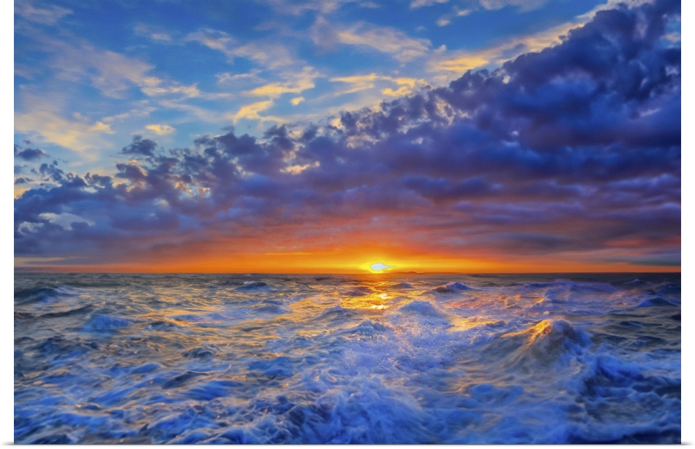 Purple and blue clouds roll in like a wave as a red sunset illuminates a glistening sea.