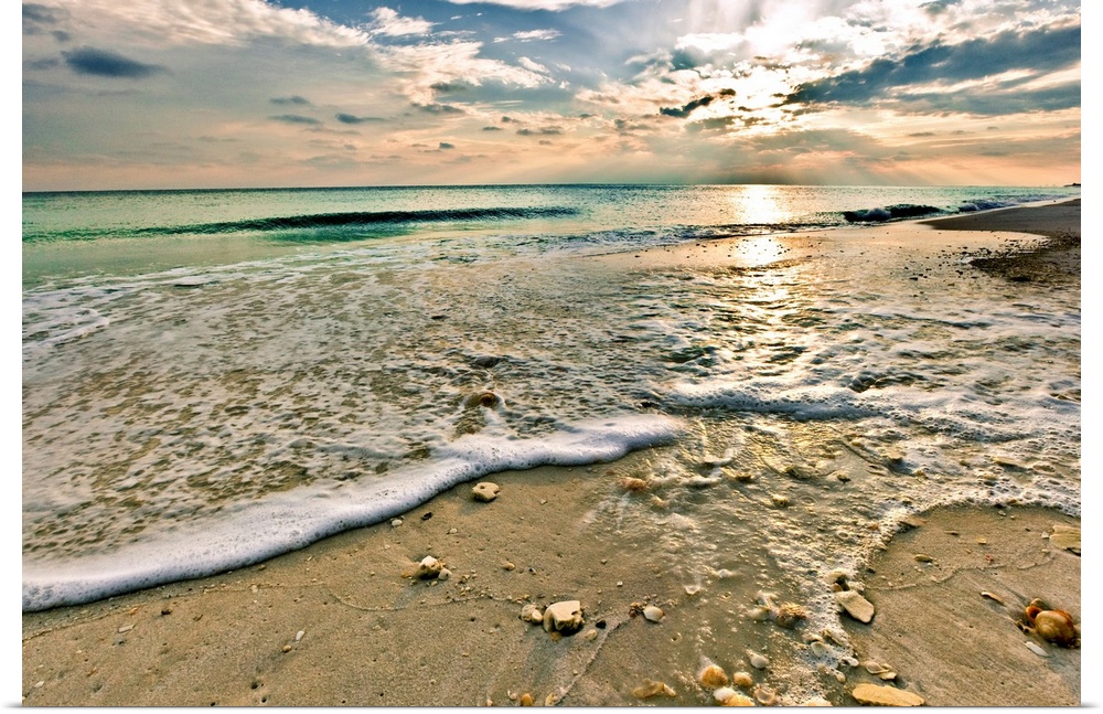 A sandy shell covered beach and emerald green waves under a bright sunset. A very tranquil and relaxing Florida vacation s...