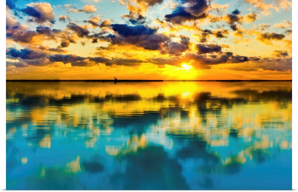 A blue and yellow sunset lake reflection of a skyscape.