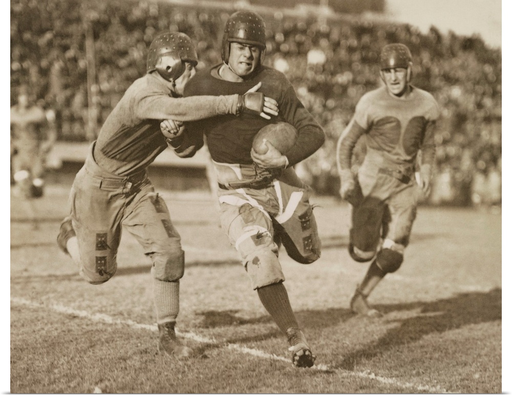 1920s football action. Hundreds of spectators watch from stadium seats.