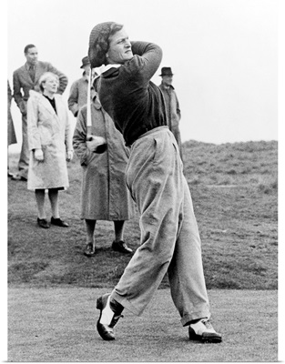 Babe Didrikson, watching golf ball as she completes her swing
