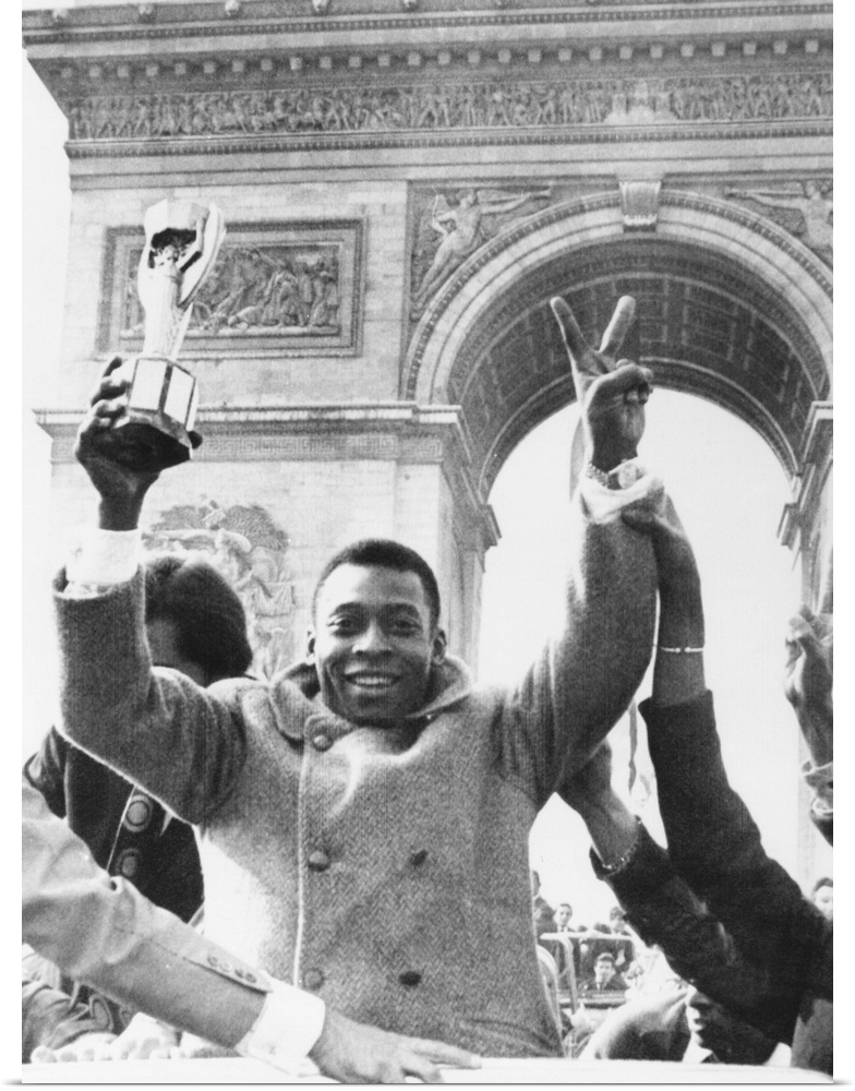 Brazilian soccer star Pele waves the Jules Rimet Cup from an open car on Paris' Champs Elysees. March 30, 1971. In the bac...