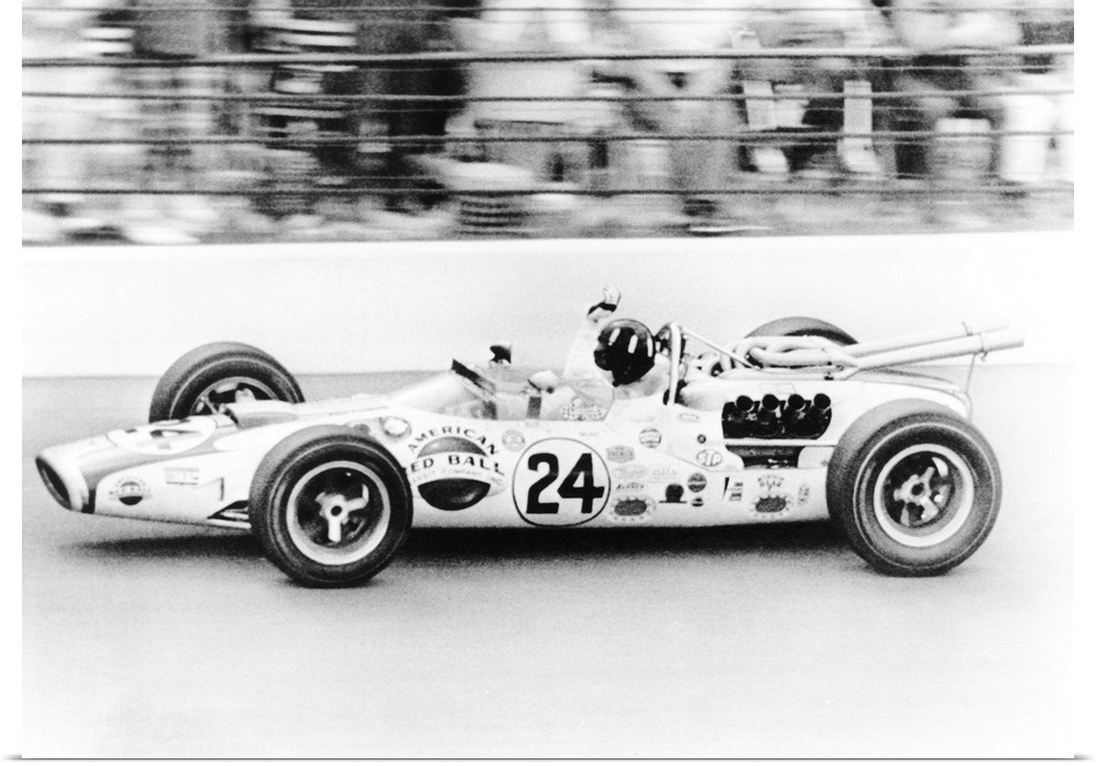 Graham Hill, waves as his car streaks toward the finish line to win the Indianapolis 500. May 30, 1966. The Golden Anniver...