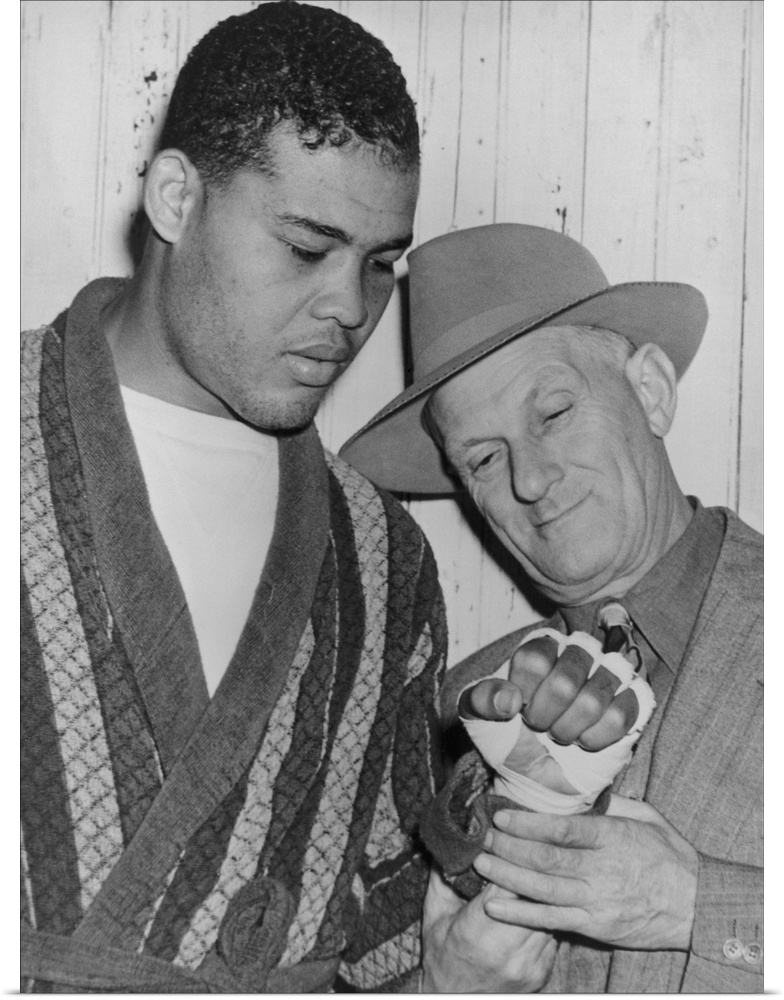 Mike Jacobs inspects Joe Louis' fist before the heavy weight champion would defend his title against Lou Nova on Sept. 29,...