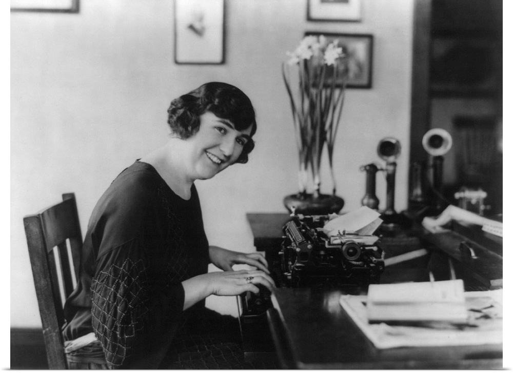 Smiling woman office worker seated at typewriter, in 1923.
