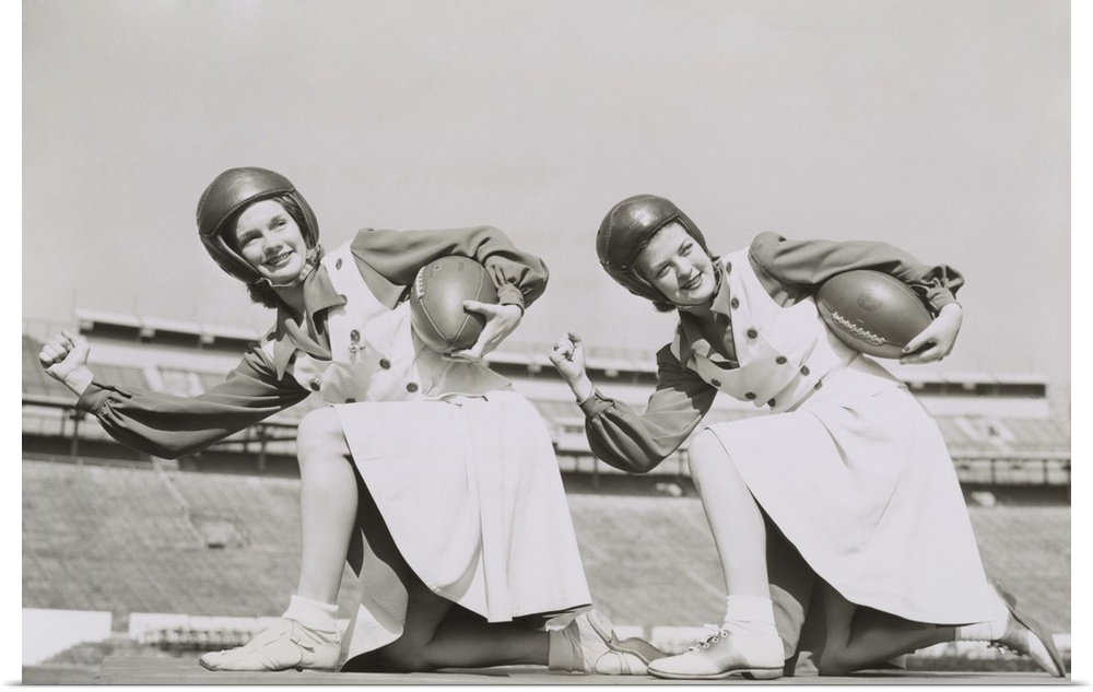 Two cheerleaders from Tulane University, Oct. 5, 1942. They are wearing football helmets and holding footballs.