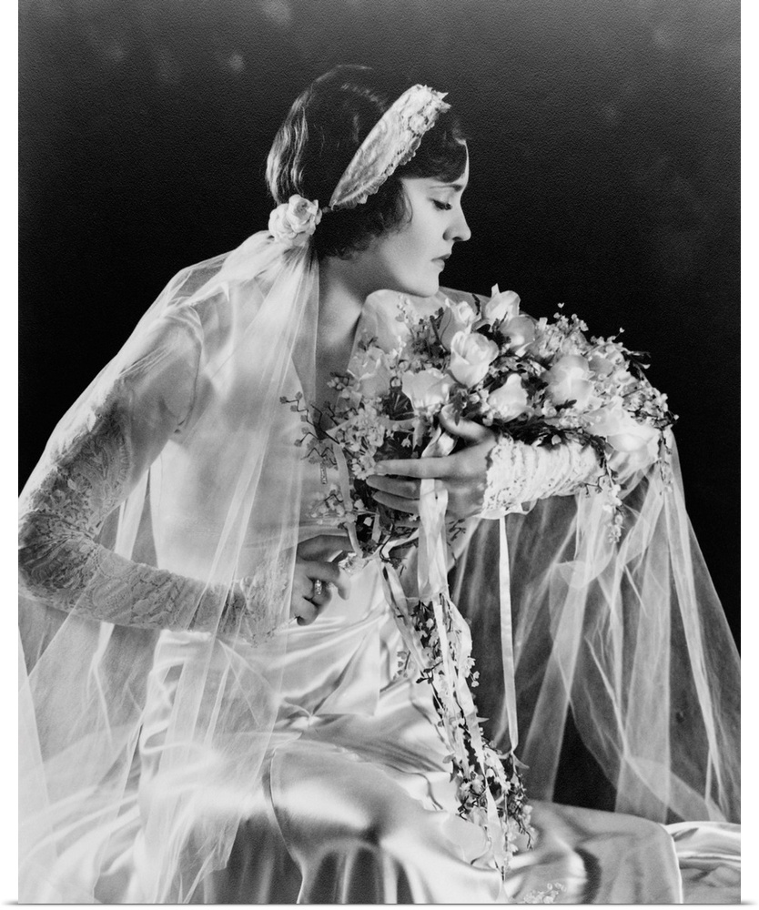 Woman in wedding gown, holding flowers, 1932.