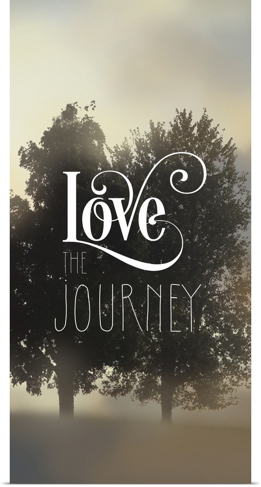 "Love The Journey" written on top of a silhouette of two trees amongst fog.
