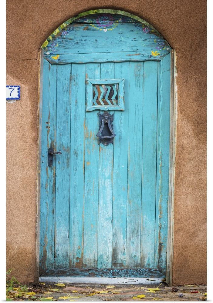 Photograph of a bright blue door in an adobe wall.