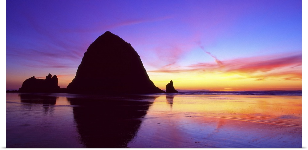 Sea stacks on the beach silhouetted at sunset, Cannon Beach, Oregon.