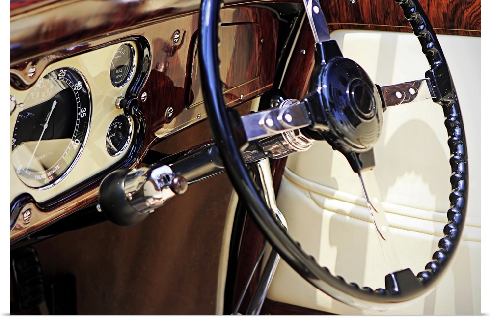Large, landscape, close up photograph of the dashboard of a classic car, polished and shining, including the steering colu...