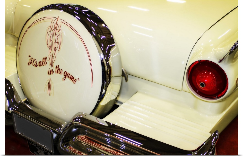The taillight and spare tire of a white customized muscle car.