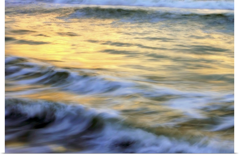Soft photograph of a sunset reflecting light on the ocean waves.
