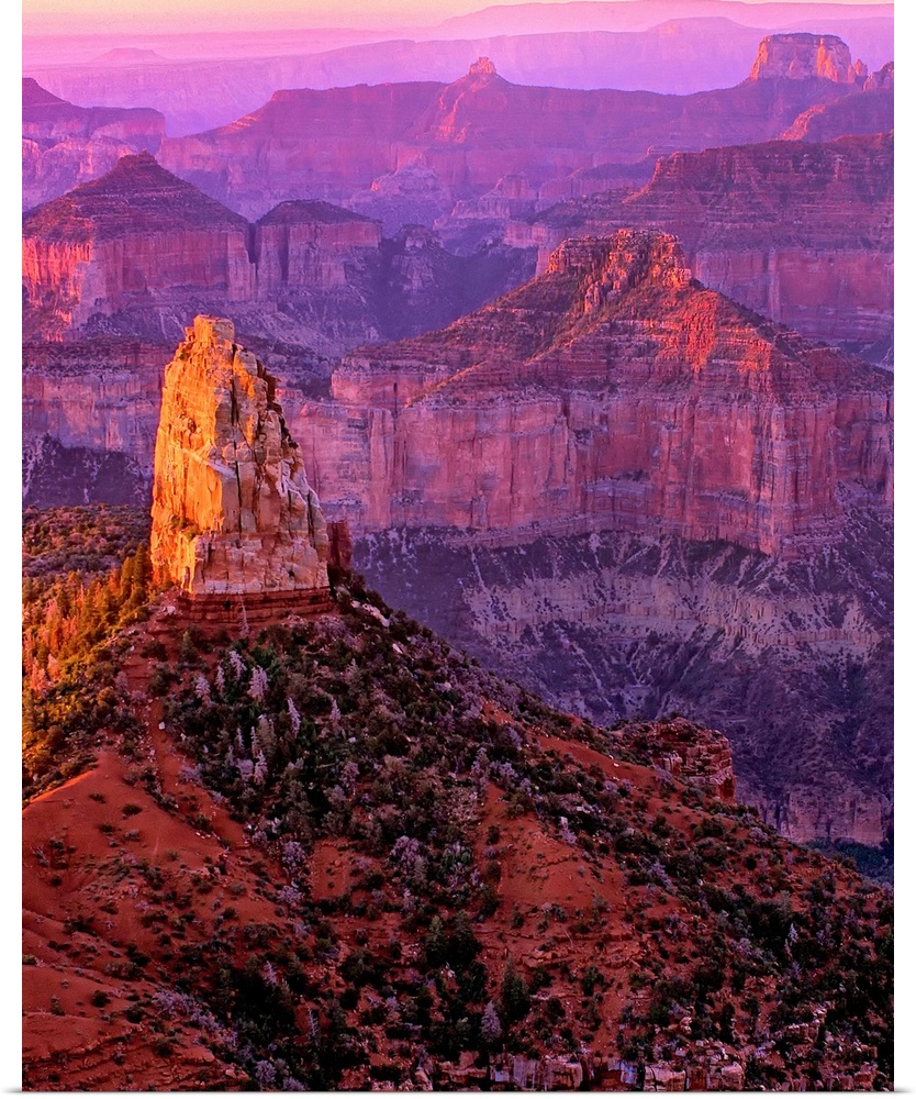 Tall rock formations in purple and red light in Arizona.