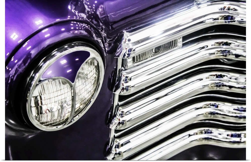 Headlight and grill detail of a bright purple vintage truck.