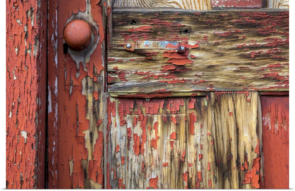 Worn wooden door with peeling paint and an old doorknob.