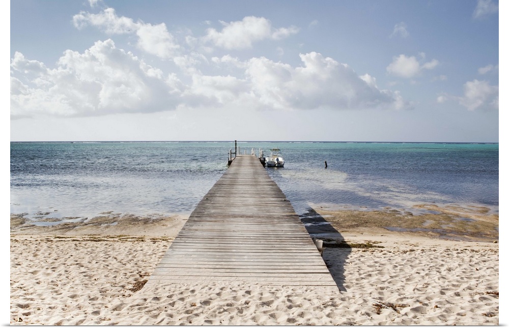 A long dock with a boat at the end stretches out into South Hole Sound on Little Cayman