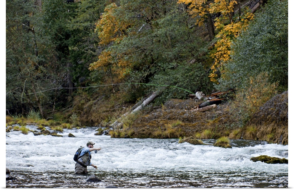 A fisherman tries his luck in the rapids of a quick moving river.