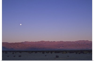 A moon above a mountain range in Death Valley National Park